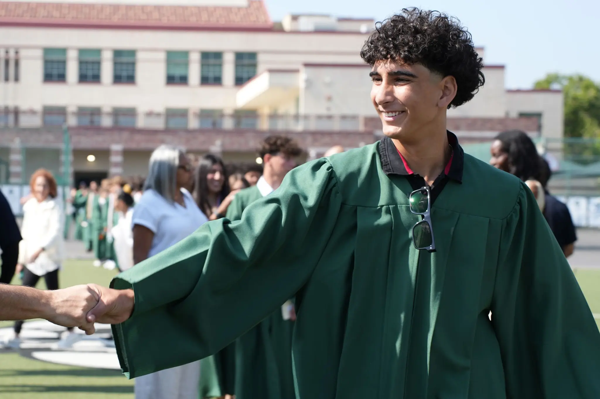 A Beverly Vista Middle School graduate shakes hands with a family member following the graduation ceremony.
