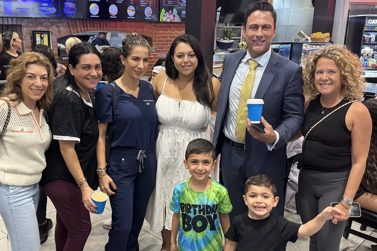 David Cienfuegos stands with community members and two children at Beverly Hills Bagel.
