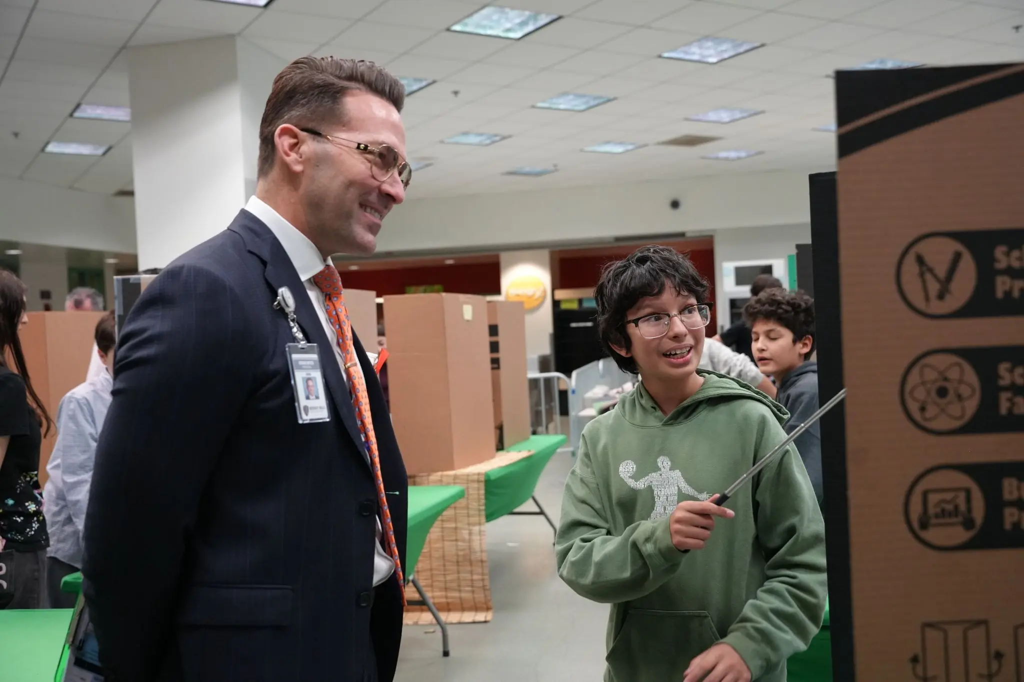 Dr. Steven Suttle, Principal of Horace Mann Elementary School and science fair judge, speaks with a student presenter during the 9th Annual BHUSD Secondary Science & Engineering Fair.