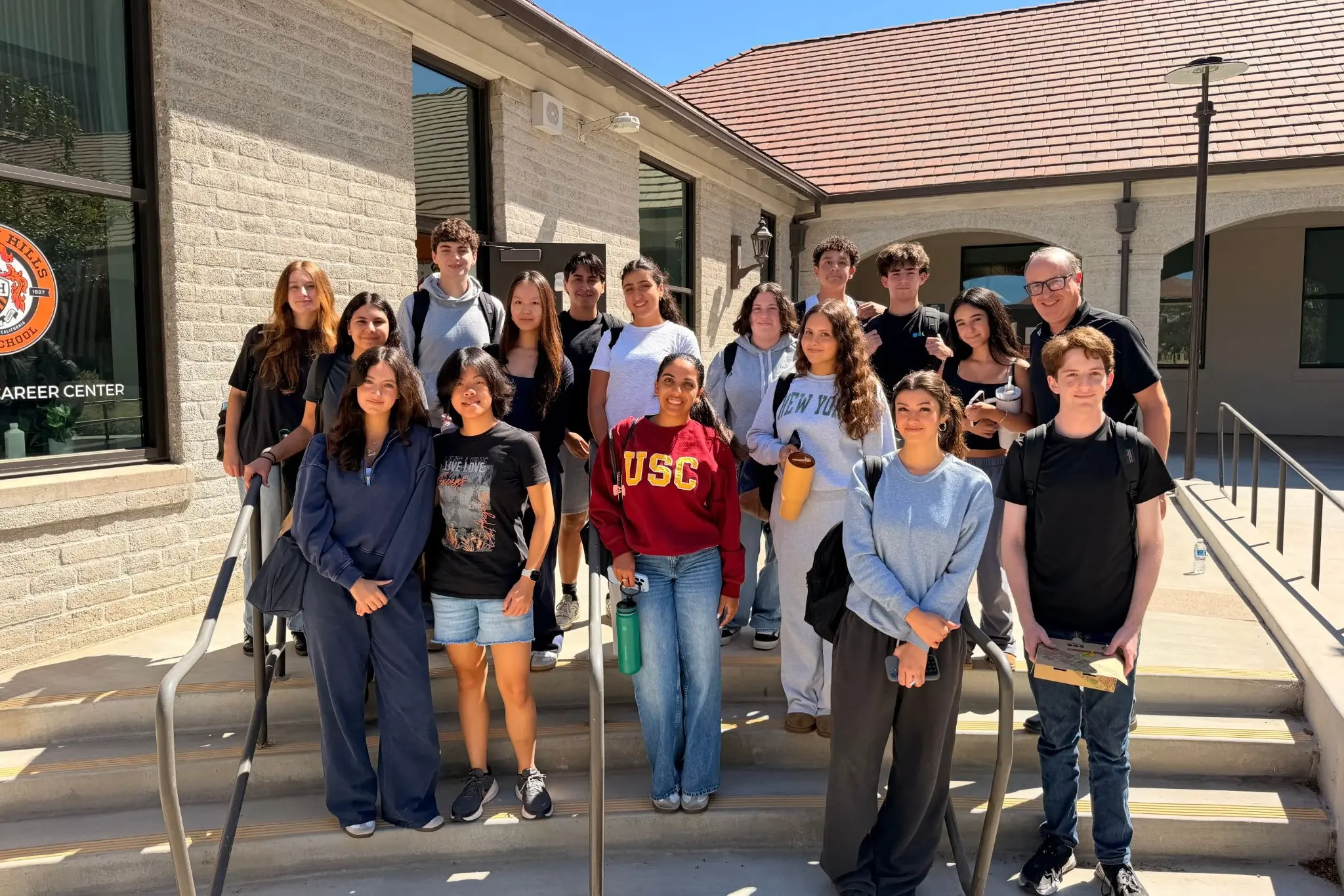 Dr. Alex Cherniss and Beverly Hills High School students standing together outside a school building.