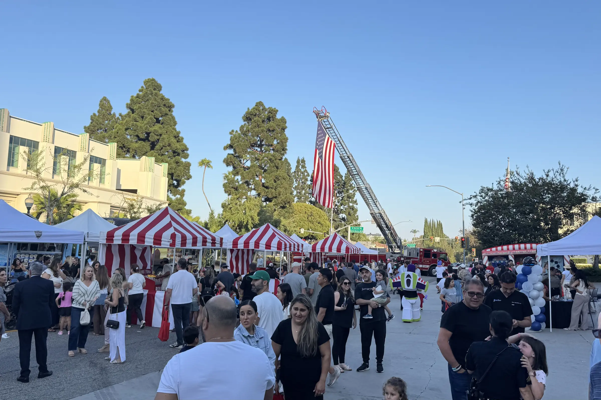 Families gather beneath the American flag while enjoying public safety exhibits, entertainment and children's activities at National Night Out.