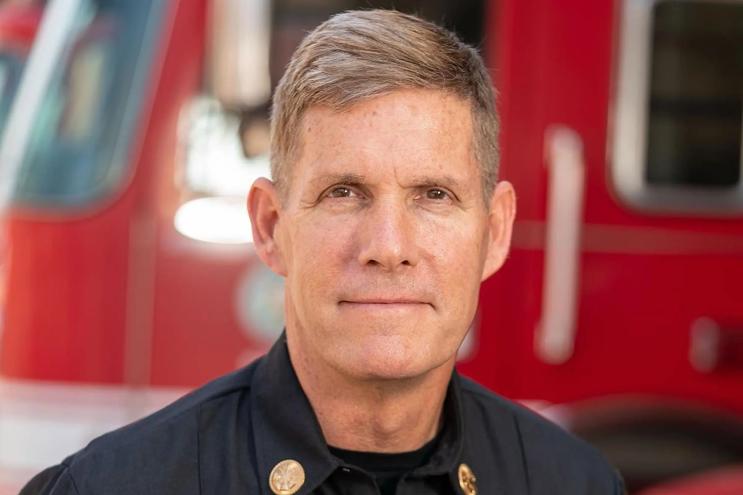 Alfred Poirier in fire department uniform in front of a fire engine.