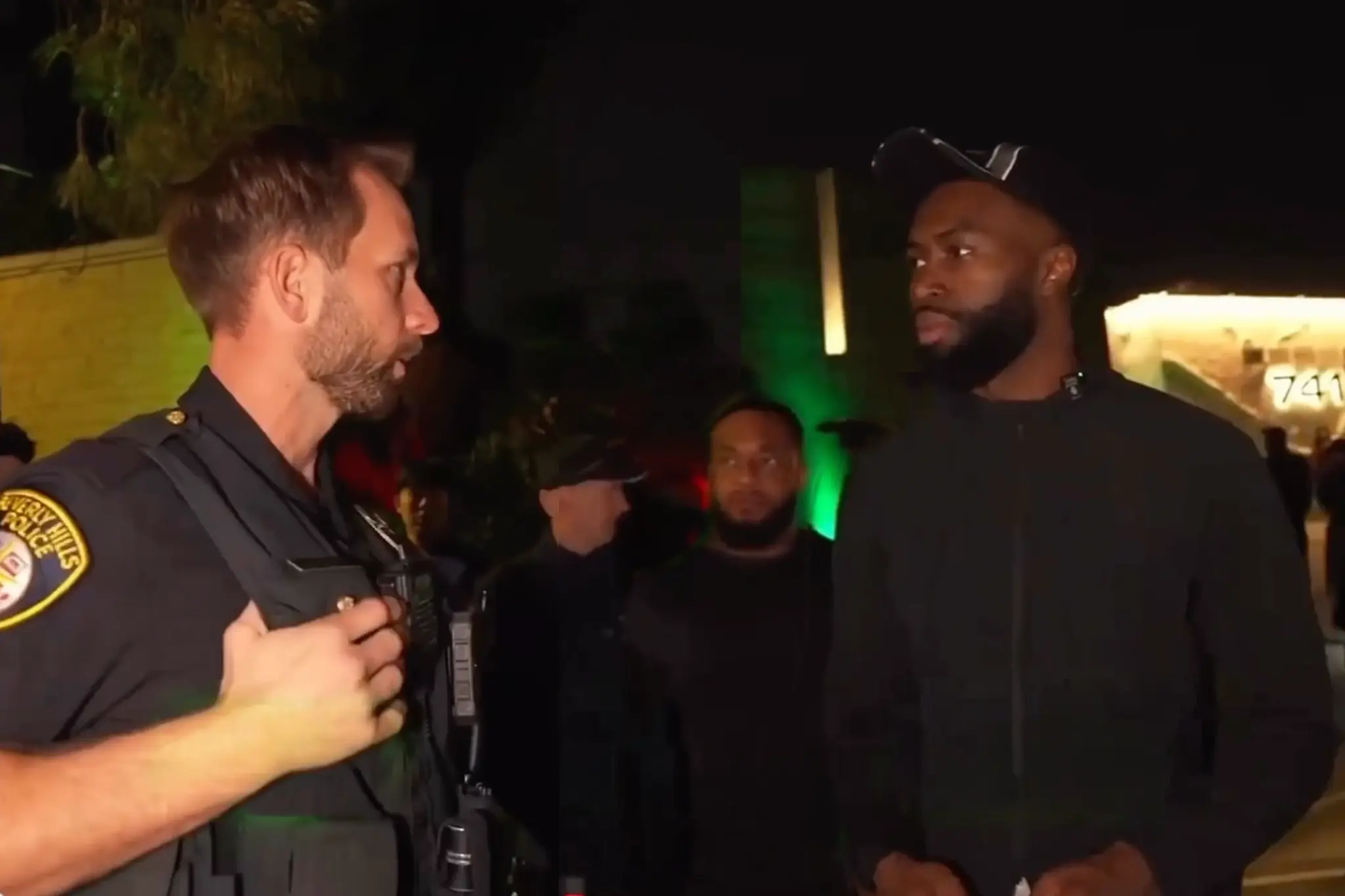 Jaylen Brown speaks with a Beverly Hills police officer outside a private residence after an unpermitted event was shut down Saturday evening.