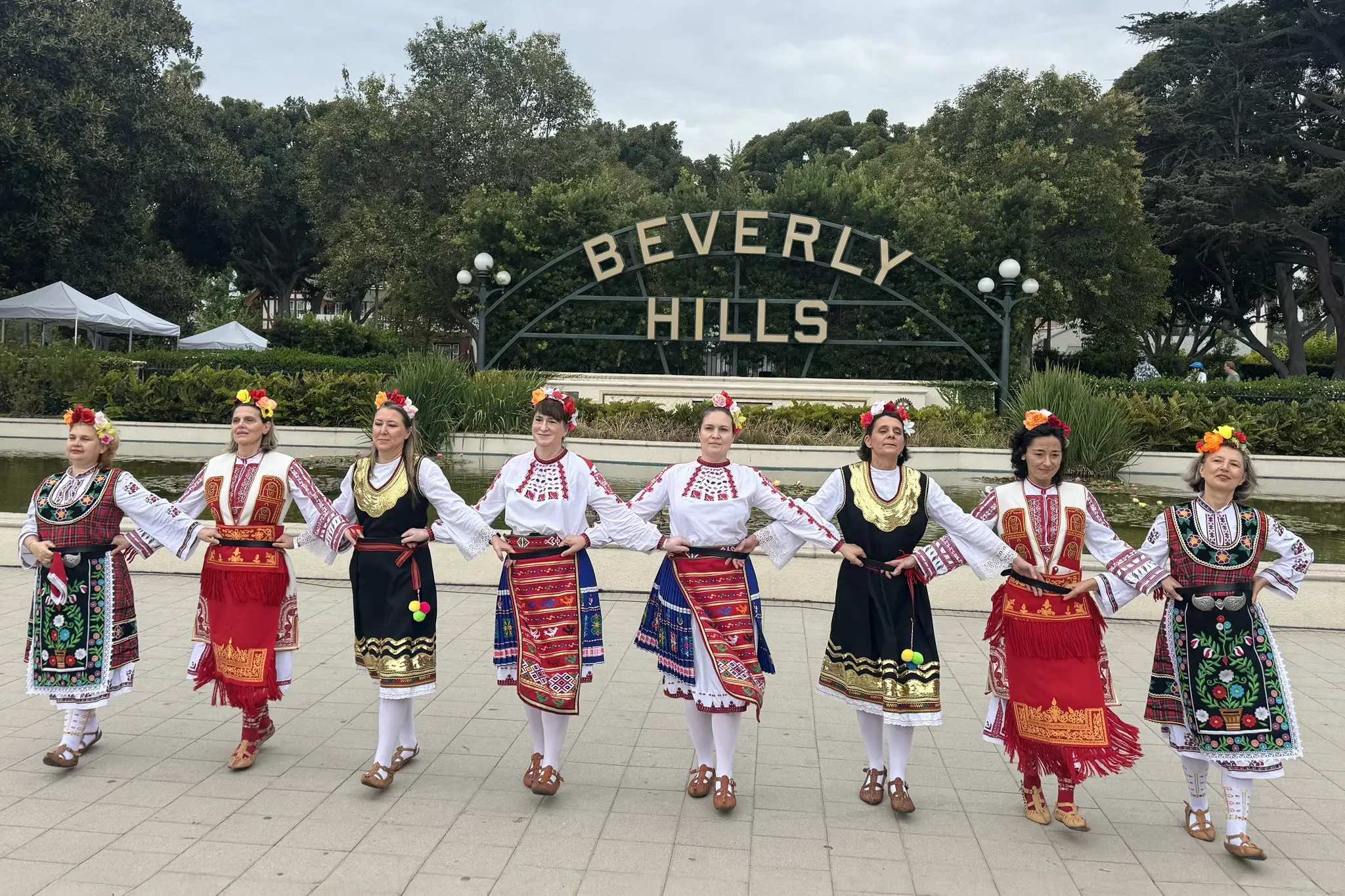 XoroTroptzi Bulgarian Folk Dance Ensemble performs in front of the Beverly Hills sign during Festival Beverly Hills at Beverly Gardens Park on July 12, 2026.
