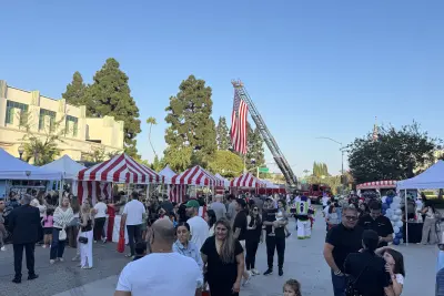 Families gather beneath the American flag while enjoying public safety exhibits, entertainment and children's activities at National Night Out.