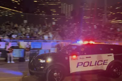 A Beverly Hills Police Department patrol vehicle circles the track with lights and sirens activated following a Norman touchdown, as fans cheer from the stands during BHHS' home opener.