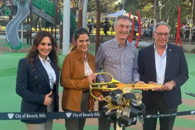 Sharona Nazarian, Mary Wells, Craig Corman and Lester Friedman stand together holding oversized gold scissors behind the ribbon at La Cienega Park.